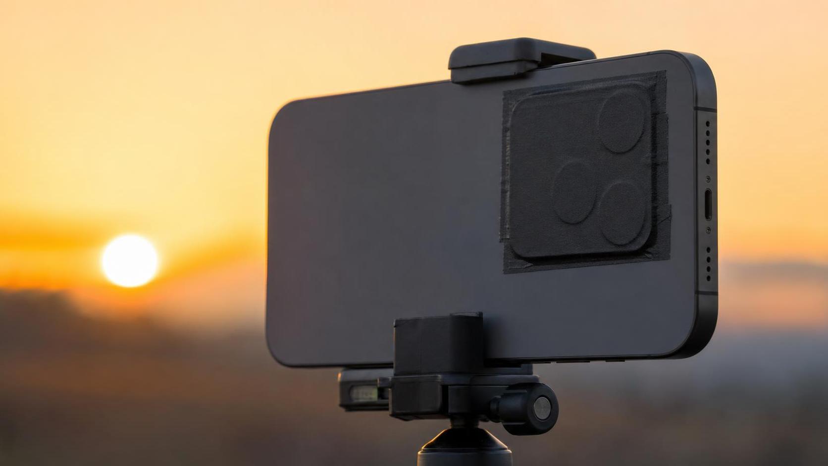 Móvil preparado con filtro solar sobre el módulo de cámara para grabar un eclipse con seguridad