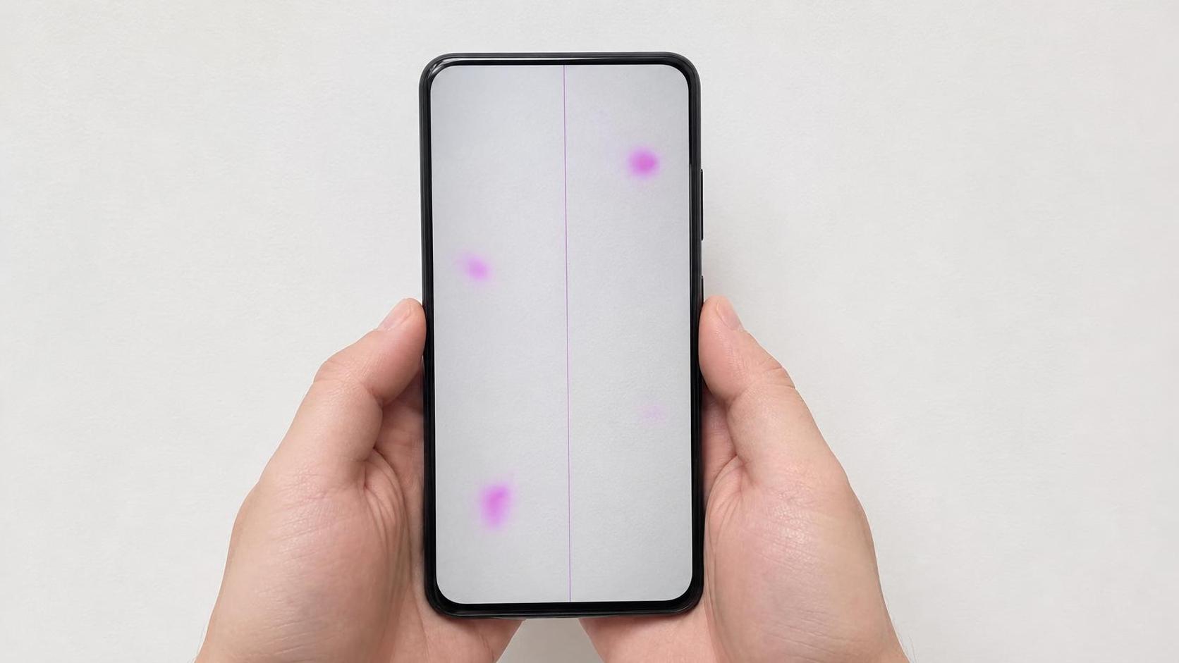 Prueba de sensor de cámara dañado con manchas magenta visibles sobre una pared blanca