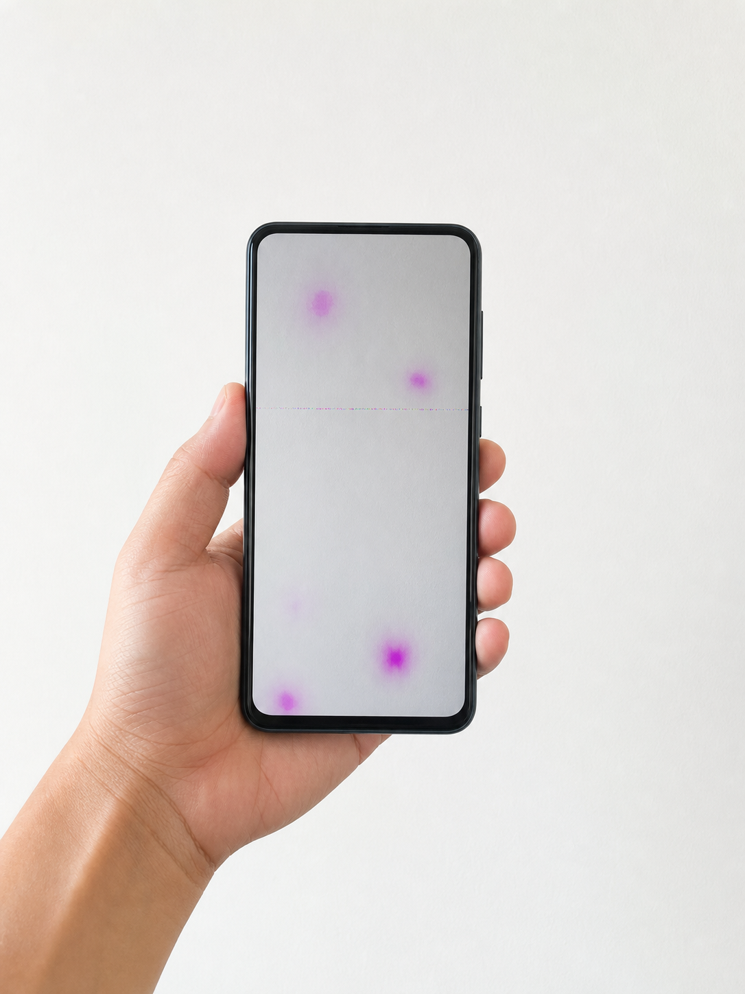 Móvil mostrando manchas magenta sobre una pared blanca durante una prueba de sensor